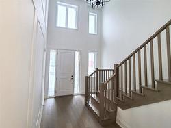 Front entrance with custom millwork wall and oak staircase