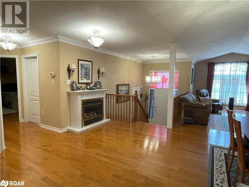 Living room with hardwood / wood-style floors, ornamental molding, and a textured ceiling