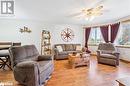 Living room featuring a ceiling fan, visible vents, and light wood-type flooring Living room featuring a ceiling fan, visible vents, and light wood-type flooring