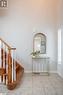 Foyer with baseboards, light tile patterned flooring, stairs, and a high ceiling Foyer with baseboards, light tile patterned flooring, stairs, and a high ceiling