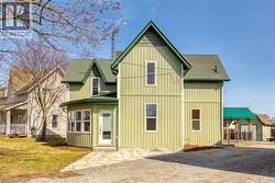 View of front of property with board and batten siding and a front lawn