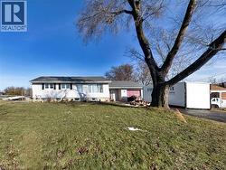 View of front of property featuring a front lawn, asphalt driveway, and a garage
