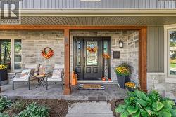 Property entrance with a porch, stone siding, and board and batten siding