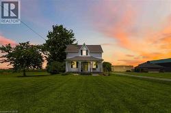 Two-story traditional farmhouse featuring a gabled roofline and a covered front porch