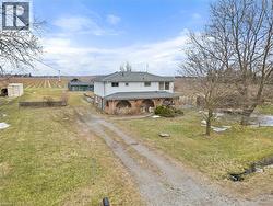 View of front of home featuring driveway, a rural view, a front lawn, and brick siding