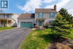 The property features a two-story exterior with light-colored siding, a dark roof, and a prominent brick chimney