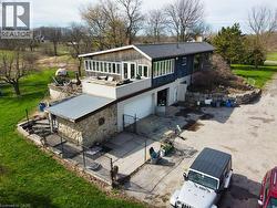 The property features a stone and wood exterior, with a garage and an expansive grassy area