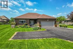 Brick exterior with a brown shingle roof, a two-car garage, and a paved driveway