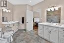 Bathroom featuring dual vanities with white countertops and undermount sinks, illuminated by contemporary light fixtures.