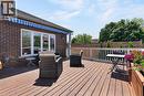 Expansive wood-finish deck with white railings and an awning.