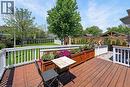 Expansive wood-finish deck featuring white railings a ramp.