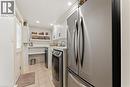 Frigidare fridge, washer, dryer. Gravelle white shaker cabinetry. Quartz countertop. Deep sink with Kohler handspray. Main floor. Side door. Adjoins mudroom.