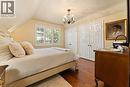Southeast bedroom. 2 double closets, one with a built in desk. Built in vanity with sink. California shutters. Bronze toned chandelier.