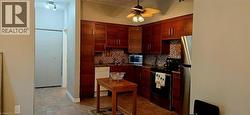 Kitchen featuring wood-finish cabinetry, patterned tile backsplash, and dark countertops
