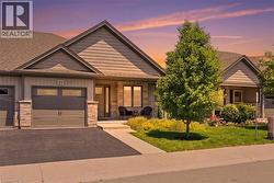 Contemporary residence featuring a two-car garage with frosted glass panels, stone accents, and a covered entryway
