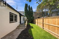 Siding exterior with contrasting trim, private fenced yard, manicured lawn, and mature trees