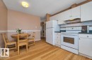 Kitchen featuring white cabinetry, dark countertops, a white electric range, and a white refrigerator