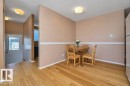Inviting dining area featuring wood-finish flooring, a chair rail accent, and a built-in refrigerator