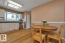 Kitchen featuring light wood-finish flooring, white cabinetry, dark countertops, and a bay window