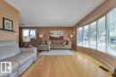 Spacious living area featuring light wood-finish flooring, a curved window wall, and a neutral color palette