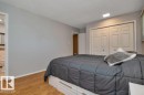 Bedroom featuring light wood-finish flooring, light gray wall paint, and white bi-fold closet doors