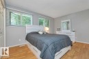 Bedroom featuring wood-finish flooring, light gray walls, and white trim