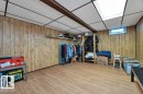 Finished room featuring wood-finish paneling, a drop ceiling, and wood-finish flooring
