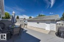 Spacious outdoor deck with gray composite decking, privacy fencing, and a detached single-car garage featuring white vinyl siding