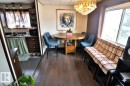 This dining area features hardwood style flooring, a window, and a decorative light fixture