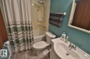 Bathroom featuring a bathtub with a shower, a toilet, and a vanity with a sink and faucet