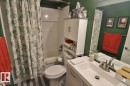 This bathroom features a vanity with a sink and a silver-toned faucet, a mirror, and a bathtub with a shower