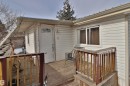 The property features white siding and a wooden deck with railing