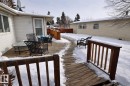 The property features a wood deck with a railing and outdoor seating