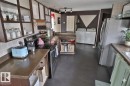 The kitchen features a stainless steel refrigerator, an electric range, and ample countertop space