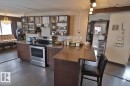 The kitchen features dark wood cabinetry, a stainless steel range, and a tiled backsplash