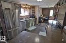 The kitchen features stainless steel appliances, including a refrigerator and dishwasher, with a double basin sink and track lighting
