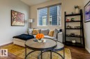 Bright living area featuring wood-finish flooring, a large window, and light-toned walls