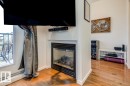 Built-in fireplace with a black surround set into a white mantel, complemented by wood-finish flooring and a white baseboard trim