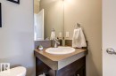 Corner vanity with an integrated sink, polished chrome faucet, full-width mirror, and dark wood-finish cabinetry