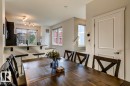 Dining area featuring a wood-finish dining table and direct sightlines to the kitchen pass-through with a granite-look countertop