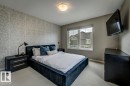 Interior room featuring a patterned accent wall, neutral wall paint, and a double-pane window with a roller shade