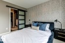 Bedroom featuring patterned wallpaper, neutral wall tones, and carpet flooring