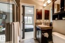 Bathroom featuring a dark wood-finish vanity with an undermount sink, a large wall-mounted mirror, and a coordinated dark wood-finish medicine cabinet