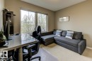 Bright room featuring large window, neutral paint, light carpet, and built-in shelving