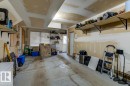 Spacious garage with exposed drywall, concrete flooring, and multiple built-in storage shelves