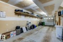 Spacious garage featuring a concrete floor, overhead lighting, and built-in shelving units