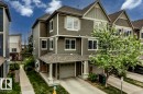 Multi-level townhome featuring a neutral exterior siding, white trim accents, and a covered entry