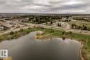 Expansive pond with natural green surroundings, bordering an arterial road