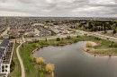 Expansive aerial capturing a neighborhood with varied residential structures and a large body of water