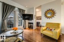 Living area featuring wood-finish flooring, a built-in fireplace, and double glass doors leading to an outdoor balcony